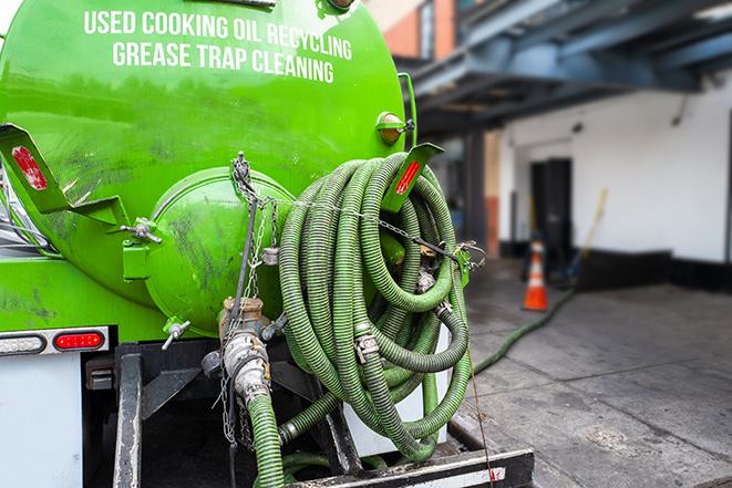 a technician pumping a grease trap in a commercial building in Reseda